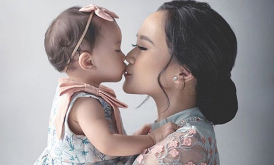 mother kissing her baby girl