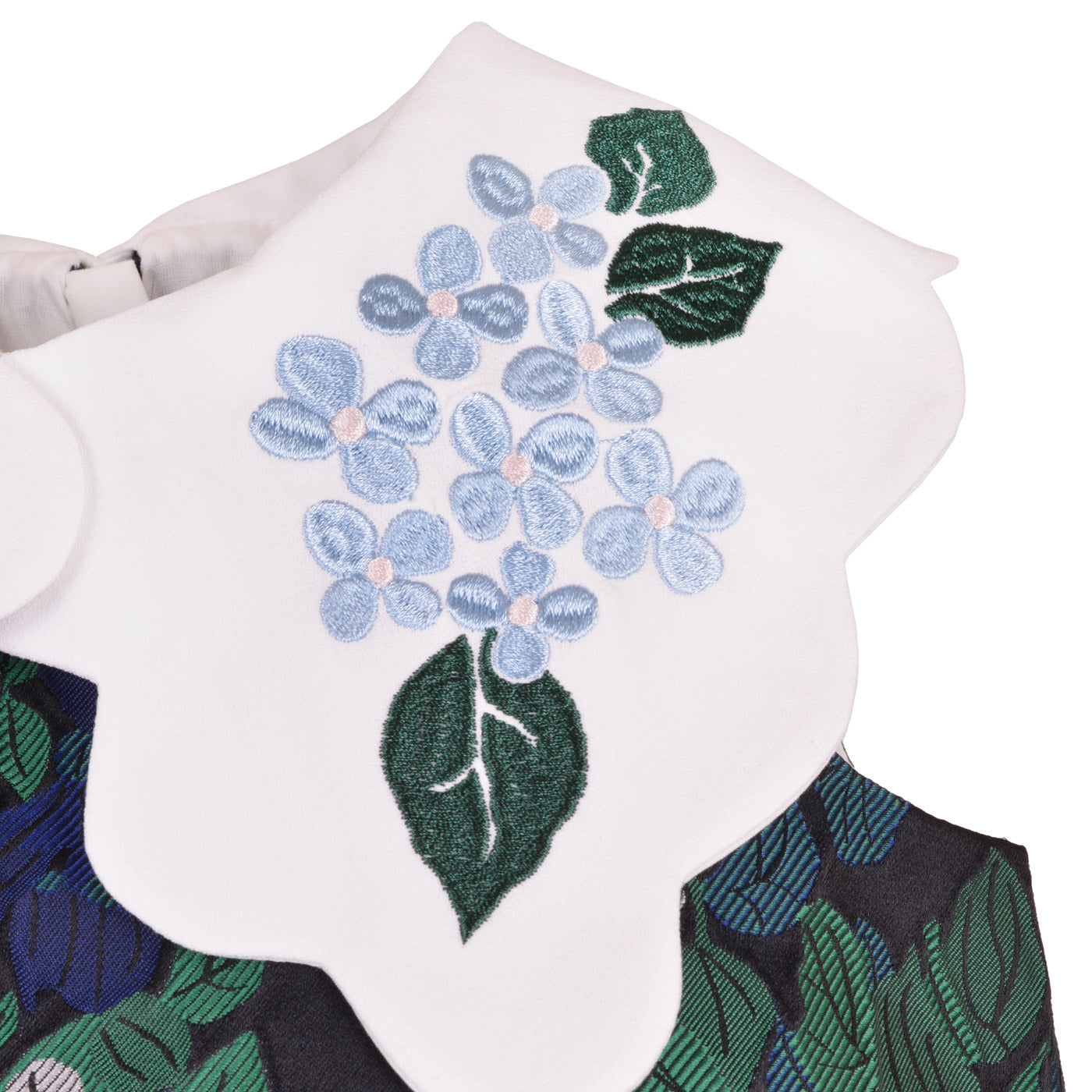 Embroidered floral applique at scalloped white neckline: blue blossoms and green leaves