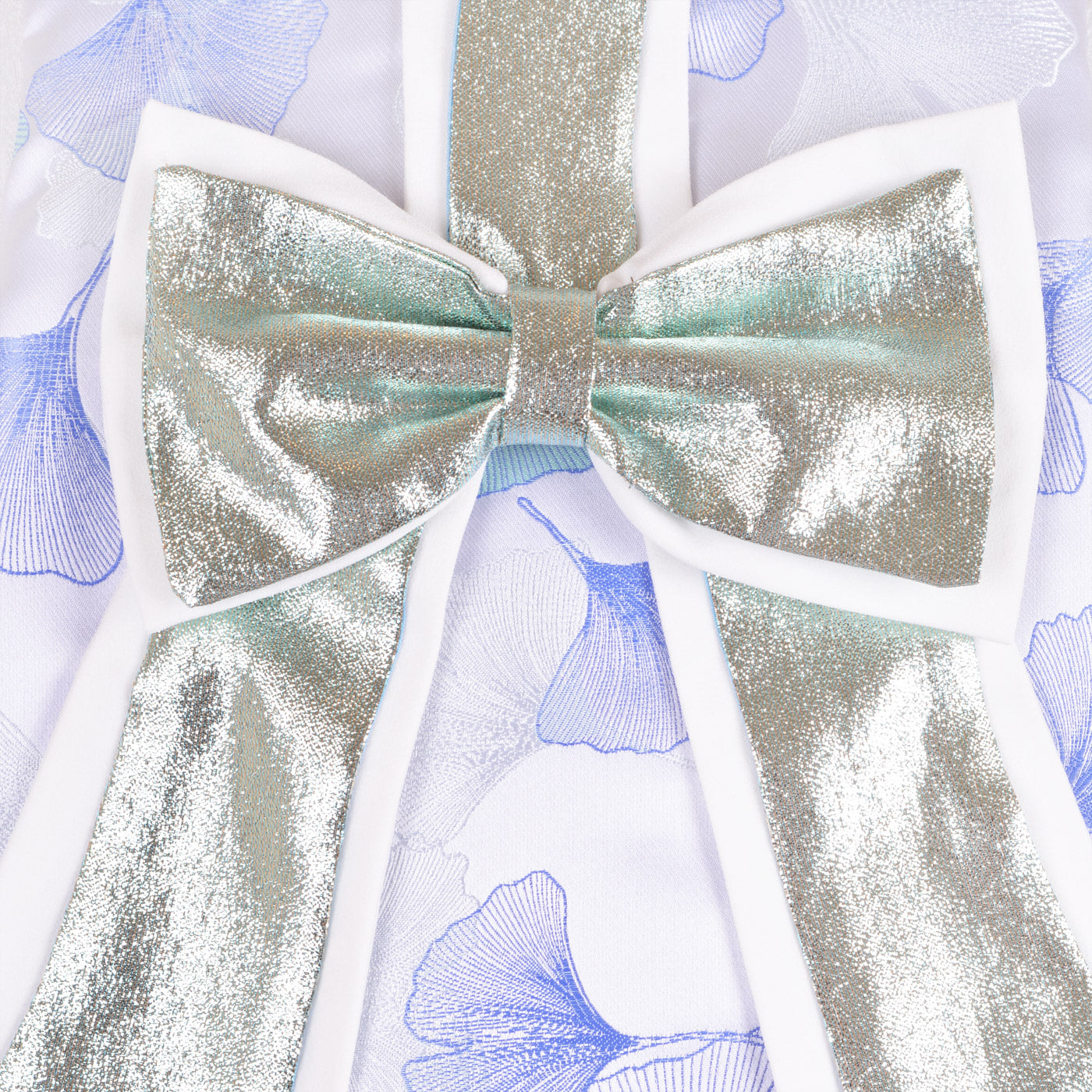 Metallic gold bow applique with iridescent sheen on blue floral dress