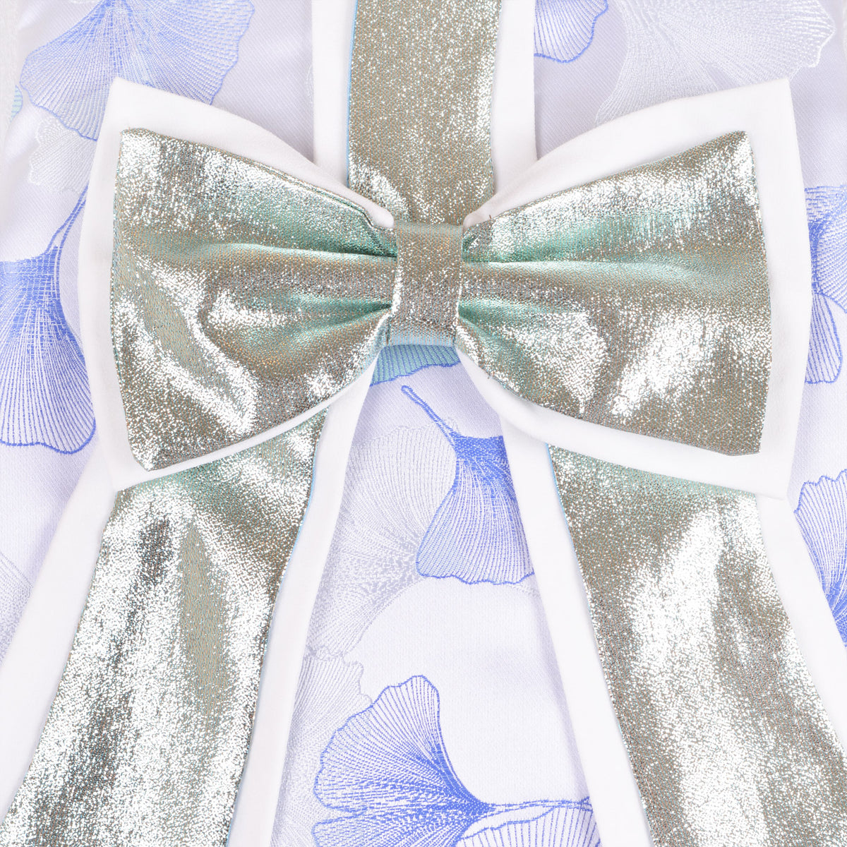 Metallic gold bow applique with iridescent sheen on blue floral dress