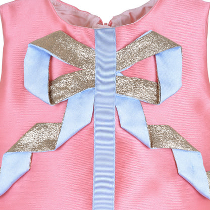 Close-up of pink dress neckline with blue ribbon bow and glitter accents