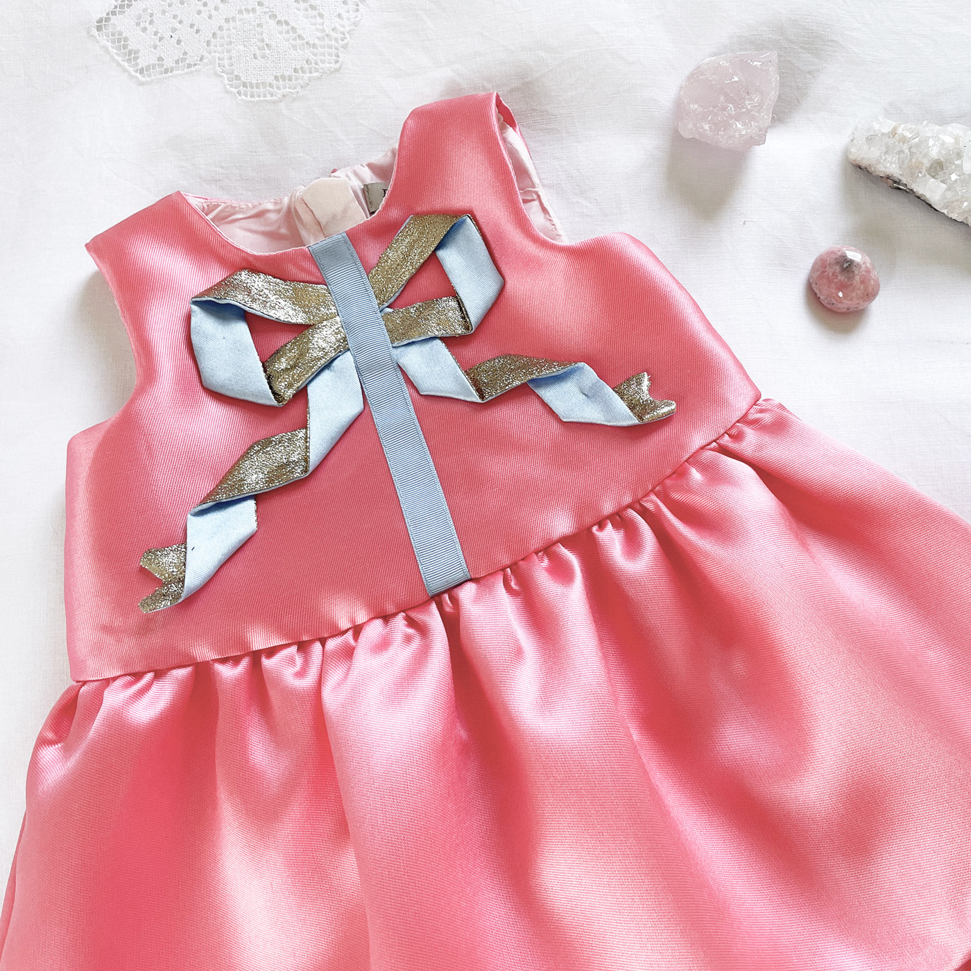Pink satin dress with tiered skirt and multi-piece ribbon bow applique