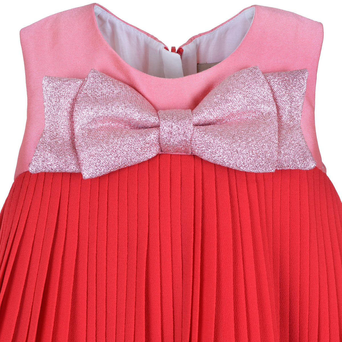 Pink sleeveless dress with glitter bow at front and red pleated skirt