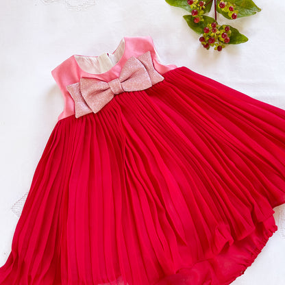 Red pleated trapeze dress with pink bow and contrast pink bodice