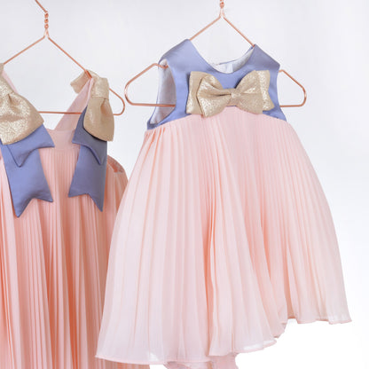 Pleated trapeze dress with gold bow, pink pleated skirt and blue collar