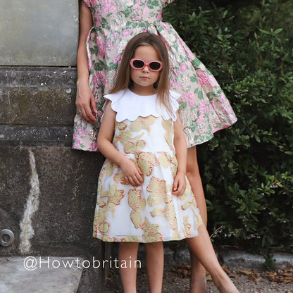 Kids scalloped bib dress with white scalloped collar and pastel animal print